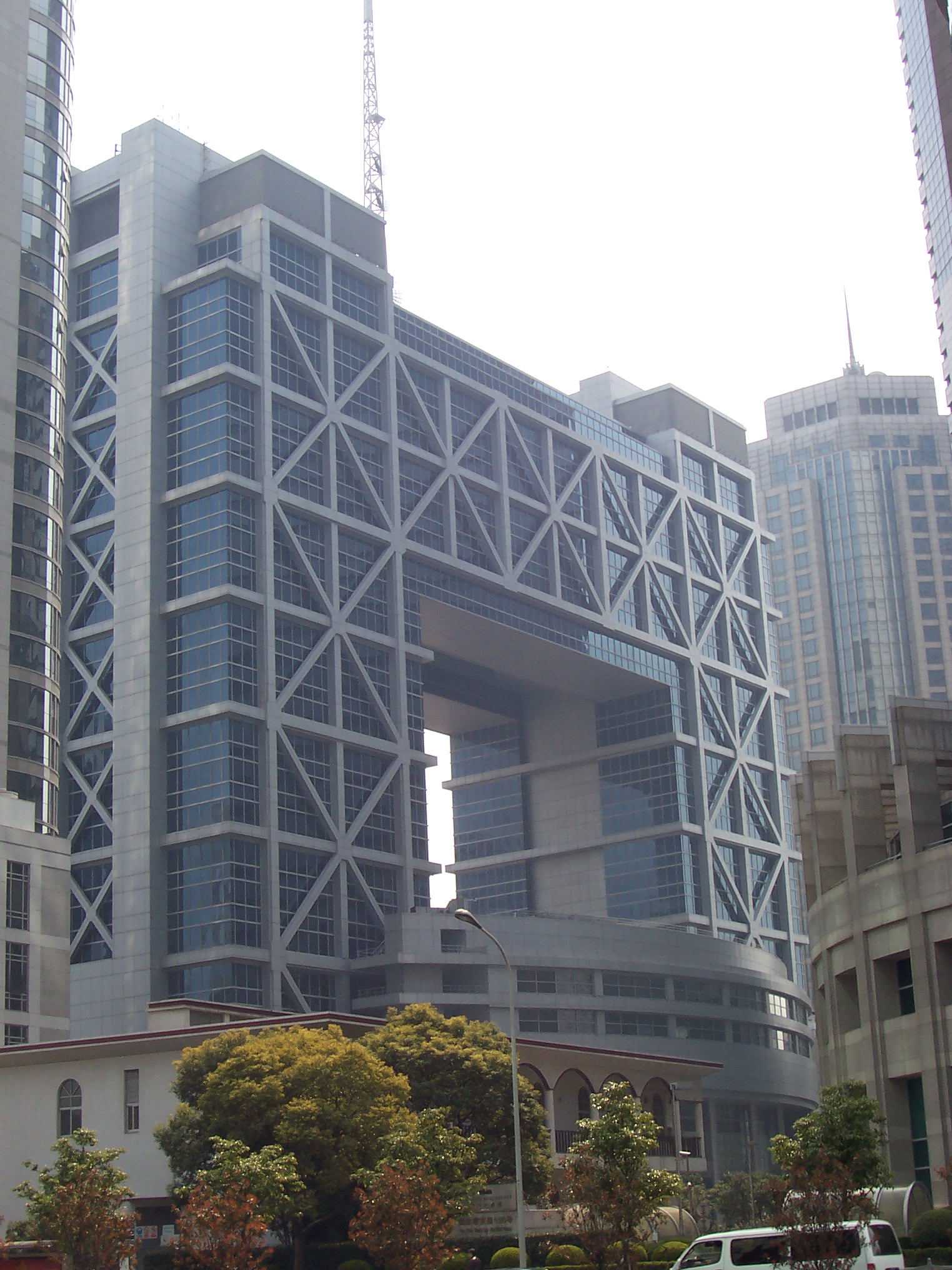 上海证券交易所大厦外景，玻璃幕墙建筑在日光下呈现深蓝色调